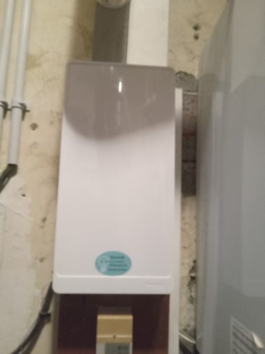 tableau fermé 26 mars Appareil de purification d'eau installé sur un mur, avec un design compact et moderne.