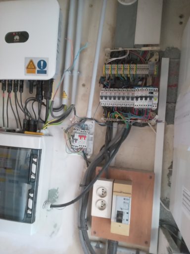 tableau initial 26 mars Tableau électrique avec disjoncteurs, câblage et compteur visible sur un mur.