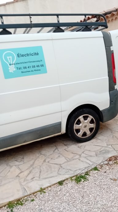 Fourgonnette blanche avec une inscription sur le côté indiquant des services électriques.